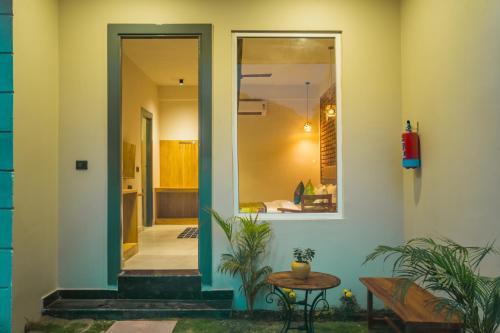 a home entrance with a glass door and a table at Tripli Hotels Sukritham in Narendranagar
