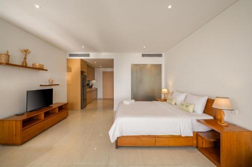 a bedroom with a bed and a flat screen tv at The Bada studio apartment - ocean view in Danang
