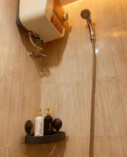 a bathroom with a shower and two bottles on a shelf at M Apartement in Seturan