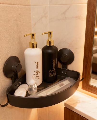 a bathroom holder with two bottles of soap and towels at M Apartement in Seturan