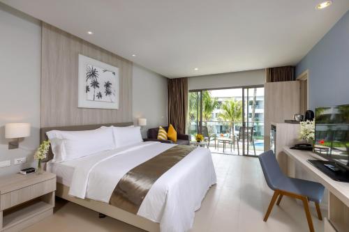 a bedroom with a large bed and a desk with a computer at X10 Khaolak Resort in Khao Lak