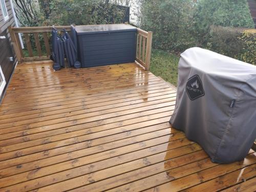 a wooden deck with a hot tub and a table at Huis-Meerwijck in Kropswolde