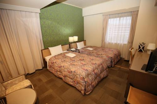 En eller flere senge i et værelse på Apoa Hotel
