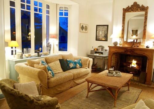 - un salon avec un canapé et une cheminée dans l'établissement La Maison rose, à Portbail