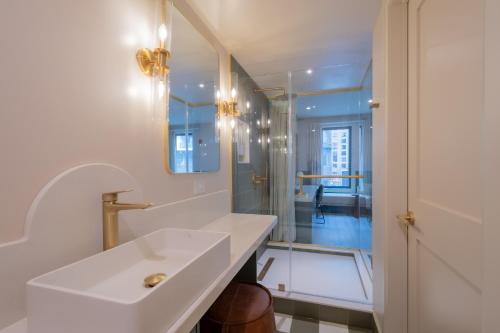 a white bathroom with a sink and a mirror at Hotel Beebop in Toronto