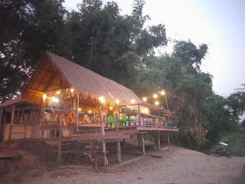a building with a roof with lights on it at Champasak Backpacker in Ban Mouang