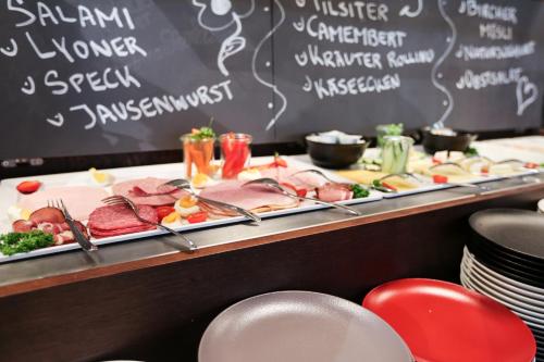 a buffet line with meats and vegetables on plates at arte Hotel Kufstein in Kufstein