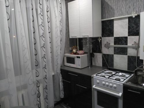 Апартаменты на Свердлова, 96А في Shuya: مطبخ مع موقد وميكروويف