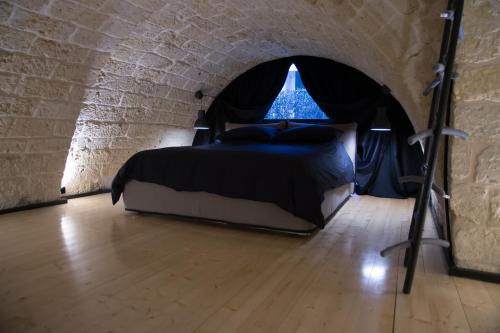 een slaapkamer met een bed in een bakstenen muur bij Cairoliapartment in Bari