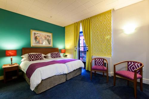 a bedroom with a large bed and two chairs at Cape Town Lodge Hotel in Cape Town