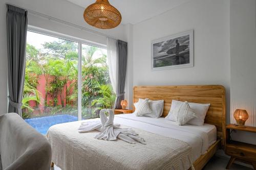 a bedroom with a bed and a large window at Polly Canggu 1BR Private Pool Villa By Bali Bliss Properties in Buduk