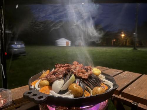 a grill with meat and other food on a table at モンゴルゲルグランピング Frontier Village in Tōma
