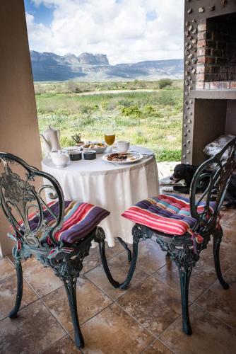 a table with a plate of food on it with two chairs at Maskam Guest Farm in Vanrhynsdorp