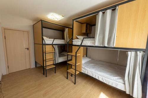 a room with three bunk beds and a door at BNM Base Camp - Ulaanbaatar in Ulaanbaatar