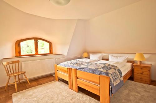a bedroom with a bed and a chair and a window at Ferienwohnung im Hochland in Kloster