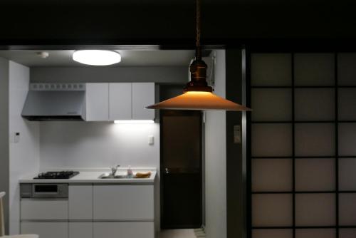 a kitchen with a light hanging from the ceiling at Tonoda Guesthouse Kyoto 殿田宿 Private 2-Story Home in Kyoto