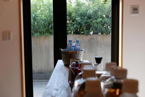 a table with bottles of water and a glass of wine at Tonoda Guesthouse Kyoto 殿田宿 Private 2-Story Home in Kyoto