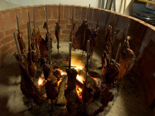 a bunch of meat is cooking over a fire at Camping Deva in Deva