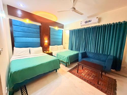 a hotel room with two beds and a couch at Comfort Lodge Executive in Islamabad