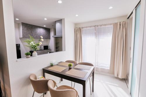 a kitchen and dining room with a table and chairs at シオヒカリ梅田 - Salt & Light Umeda in Osaka