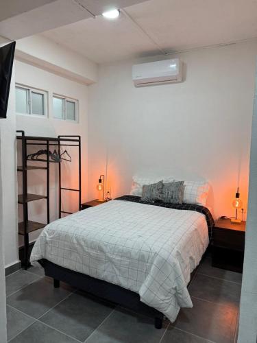 a bedroom with a bed in a room with two lamps at Freya studio IV Romantic Zone in Puerto Vallarta