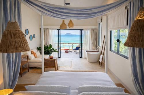 a bedroom with two beds and a view of the ocean at Baan Jai Dee Beach Front Hotel in Wok Tum