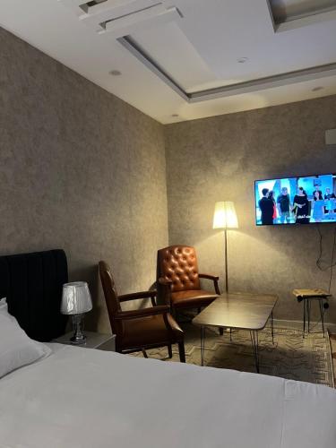 a hotel room with a bed and a flat screen tv at ملاذ للشقق المفروشة 2 in Tabuk