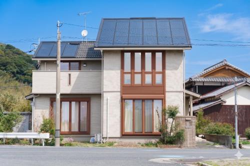 a house with solar panels on the roof at Itoshima inn 海 山 川が目の前でベッド8台 4LDK 一棟貸し in Itoshima