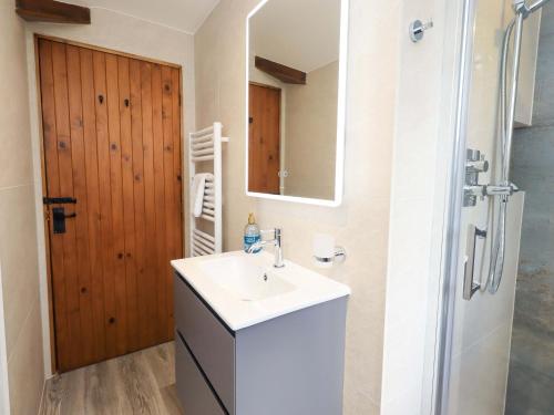 a bathroom with a sink and a mirror and a shower at High Dow Crag in Coniston