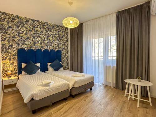 a bedroom with a blue bed and a table at Lev Or Aparthotel in Bucharest