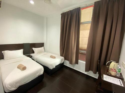 two beds in a small room with a window at Hotel O Friend in Petaling Jaya