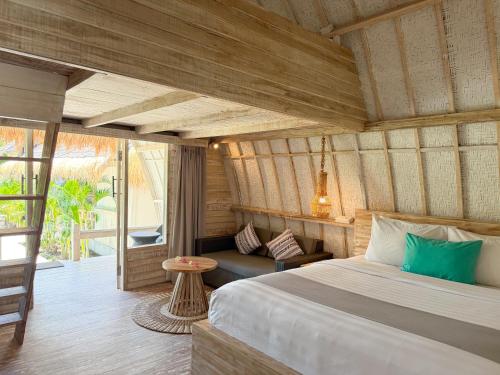 a bedroom with a bed and a couch in a room at Gili Air Escape - Adults Only in Gili Islands