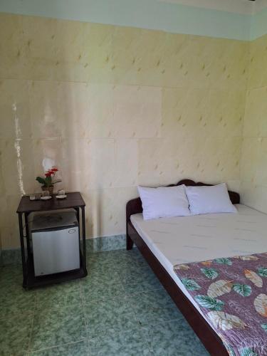 a bedroom with a bed and a table with a tv at Homestay Hồng Hoa in Hà Tiên