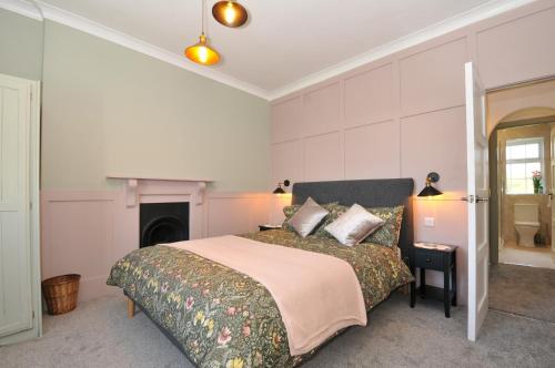a bedroom with a large bed and a fireplace at Tor View Fourwinds in Okehampton