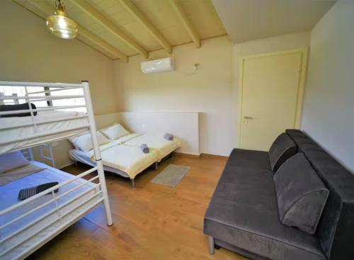 a bedroom with two bunk beds and a couch at נוף הרים בר יוחאי - בית נופש מדהים עם בריכה וג'קוזי in Bar Yohai