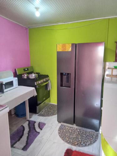 eine Küche mit einem Edelstahlkühlschrank und einem Herd in der Unterkunft Queen room in Bridgetown