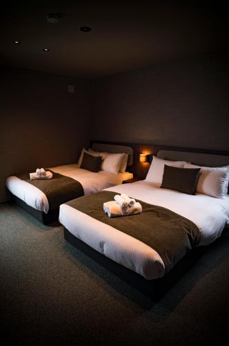 two beds in a room with towels on them at monel in Nakafurano