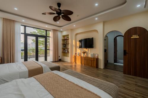 a bedroom with two beds and a flat screen tv at Mana Hotel Quảng Bình in Dong Hoi