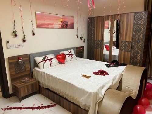a bedroom with a bed with red hearts on it at Carmel Residence - كارمل ريزيدنس in Baghdād