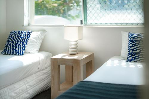 a living room with a couch and a table with a lamp at Sailport Mooloolaba Apartments in Mooloolaba
