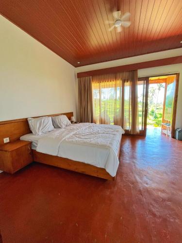 a bedroom with a large bed with a ceiling at Rinjani Vibe Bungalows in Tetebatu