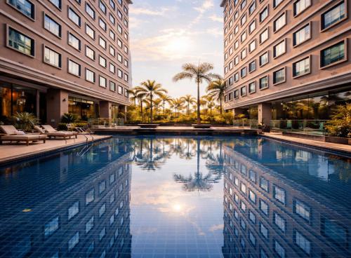 a swimming pool in the middle of two buildings at Sunday Grand Jomtien Pattaya in Jomtien Beach