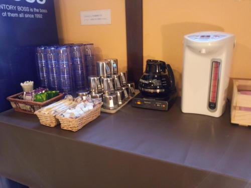 a counter with a coffee maker and baskets of cups at Hotel Matsumoto Hills in Matsumoto