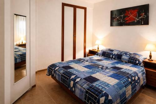 a bedroom with a bed with a blue and white plaid blanket at Depto Termas Centro in Termas de Río Hondo