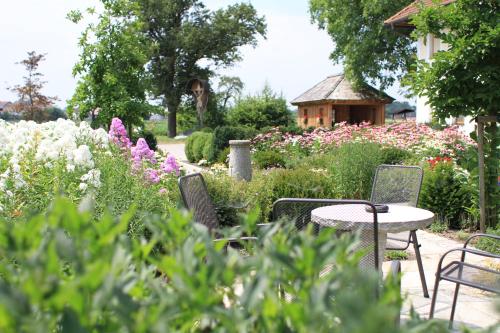 a garden with a table and chairs and flowers at Frühstückspension Herzog zu Laah in Linz