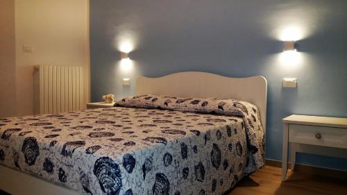 a bedroom with a bed and two lights on the wall at Affittacamere Tory in Sirolo