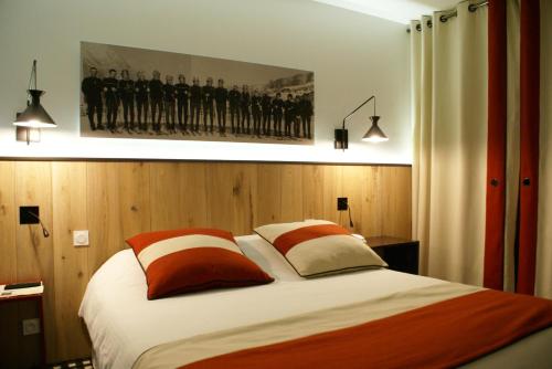 Un dormitorio con una cama con un cuadro en la pared. en Hôtel Mir, en Saint-Lary-Soulan