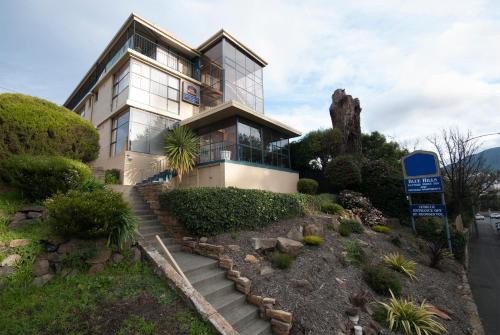 a house on a hill with stairs in front of it at Blue Hills Motel in Hobart