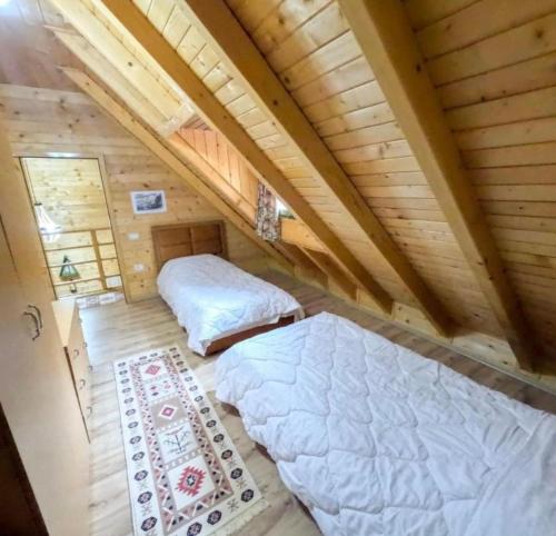 two beds in a room in a log cabin at Eco Camping Valbone in Valbonë