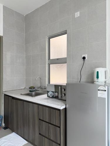 a kitchen with a sink and a refrigerator at DreamScape Apartment @ Golden Hill in Cameron Highlands